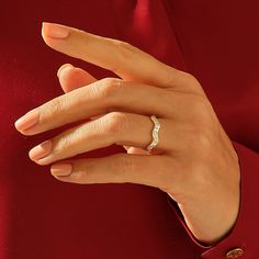 a woman's hand wearing a diamond ring