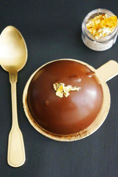 a chocolate dessert on a plate next to a spoon