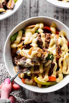 two bowls filled with beef and peppers covered in cheese