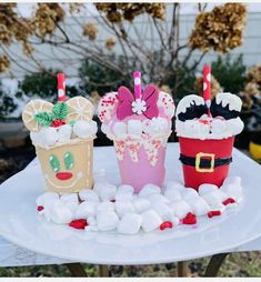 three cupcakes decorated with marshmallows on a table