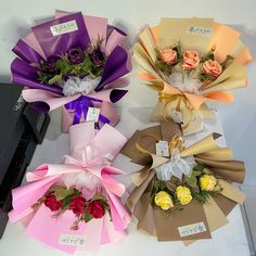 three bouquets of flowers are wrapped in brown paper and tied with ribbons on top of each other