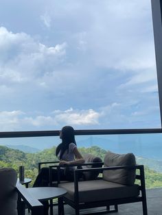 a woman sitting on top of a chair next to a table