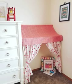 a child's bedroom with a pink canopy bed and white dresser in the corner