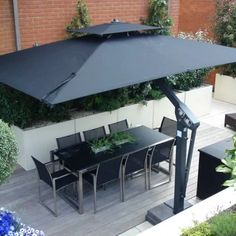 an outdoor dining area with table, chairs and umbrella