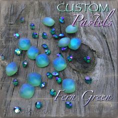 the words custom pastels are surrounded by blue and green crystals on a wooden surface