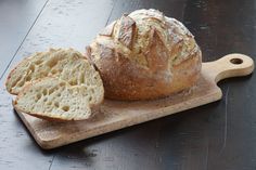 a loaf of bread sitting on top of a wooden cutting board