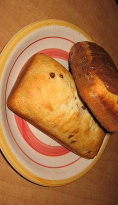 two pieces of bread sitting on top of a white and yellow plate next to each other