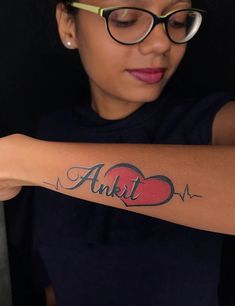 a woman with a heart tattoo on her arm