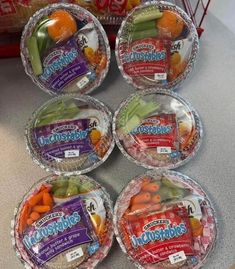 six plastic bowls filled with assorted fruits and veggies on a counter top