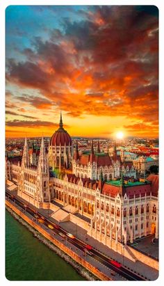 an aerial view of the hungarian parliament in budapest, with sunset over the river danube