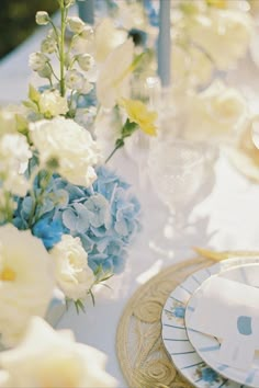 the table is set with blue and white flowers