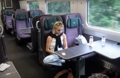 a woman sitting at a table on a train