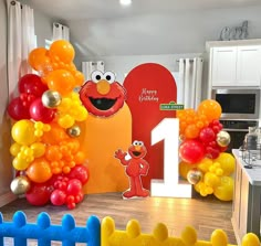 the sesame street birthday party is decorated with balloons and an elmo number one sign