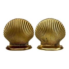 two gold shell shaped candlesticks on stands