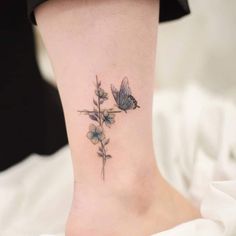 a small ankle tattoo with flowers and butterflies on it