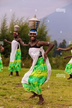 an african woman dancing with her headdress on in the field - stock image