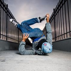 a man laying on the ground in front of a fence with his feet up and arms out