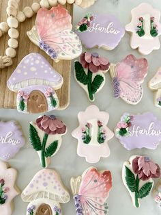 decorated cookies with flowers, mushrooms and butterflies on a table next to some macaroni shells