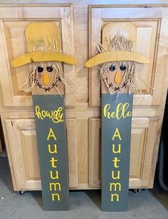 two scarecrows with hats on their heads are standing next to each other in front of wooden cabinets