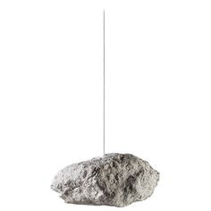 a rock hanging from a rope on a white background