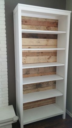 a white bookcase with wooden planks on it