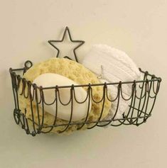 a wire basket holding two different types of towels and a star hanging on the wall