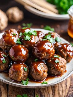 meatballs covered in bbq sauce on a plate with parsley sprigs