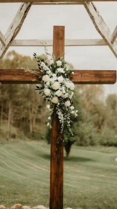 a cross decorated with flowers and greenery