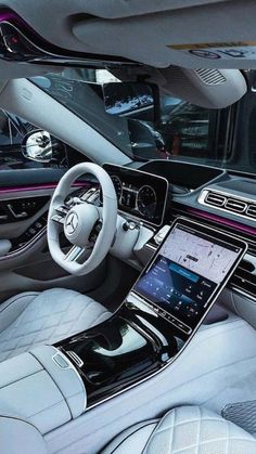 the interior of a modern car with white leather and pink trims, including steering wheel