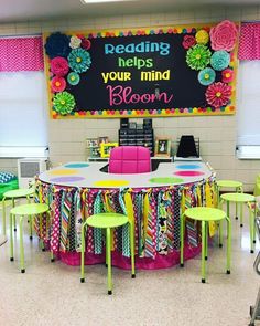 a classroom with tables, chairs and a chalkboard on the wall above it that says reading helps your mind bloom