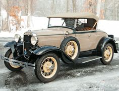 an old model car is parked in the snow