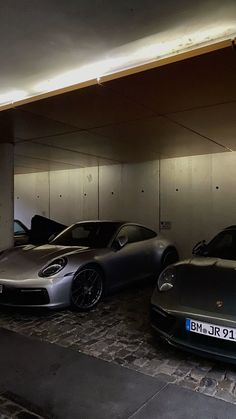 three porsches are parked in an underground parking garage with no doors on the side