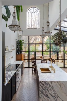 a large kitchen with marble counter tops and black cabinets