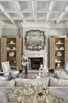 a living room filled with furniture and a fire place next to a mirror on the wall