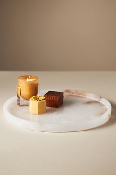 two candles on a white plate with some other items