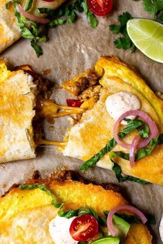 two slices of mexican pizza with meat, cheese and veggies on parchment paper