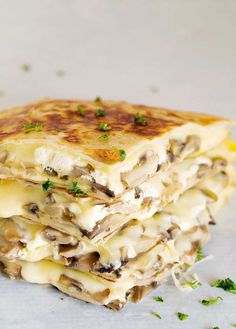 three quesadillas stacked on top of each other with melted cheese and mushrooms