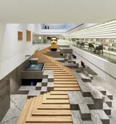 an empty library with stairs leading up to bookshelves and sculptures in the background