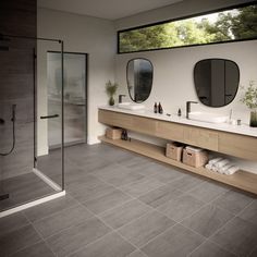 a bathroom with two sinks and mirrors on the wall, along with a walk in shower