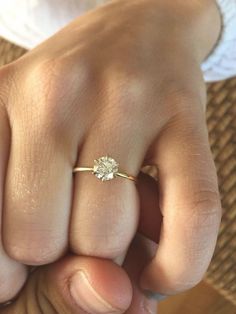 a close up of a person's hand with a diamond ring on their finger