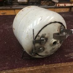 an old white helmet sitting on top of a wooden table