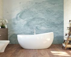 a large white bath tub sitting on top of a wooden floor