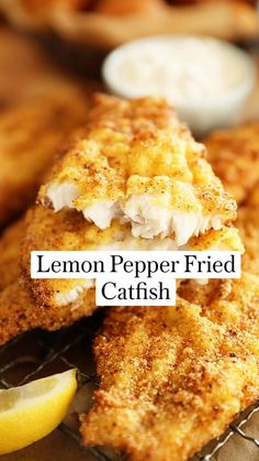 two fried fish fillets on a cooling rack with lemon wedges