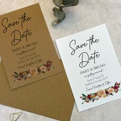 wedding save the date cards and envelopes with flowers on them next to a plant