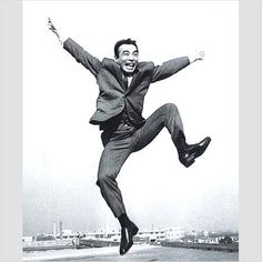 a black and white photo of a man jumping in the air