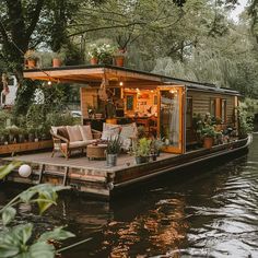 a houseboat is docked on the water with plants and potted plants in it