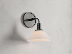 a wall light that is on the side of a wall with a white glass shade