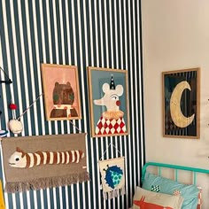 a child's bedroom with striped walls and pictures on the wall