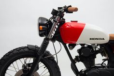 a red and white motorcycle parked on top of a field