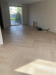 an empty room with hard wood flooring and sliding glass door leading to the outside